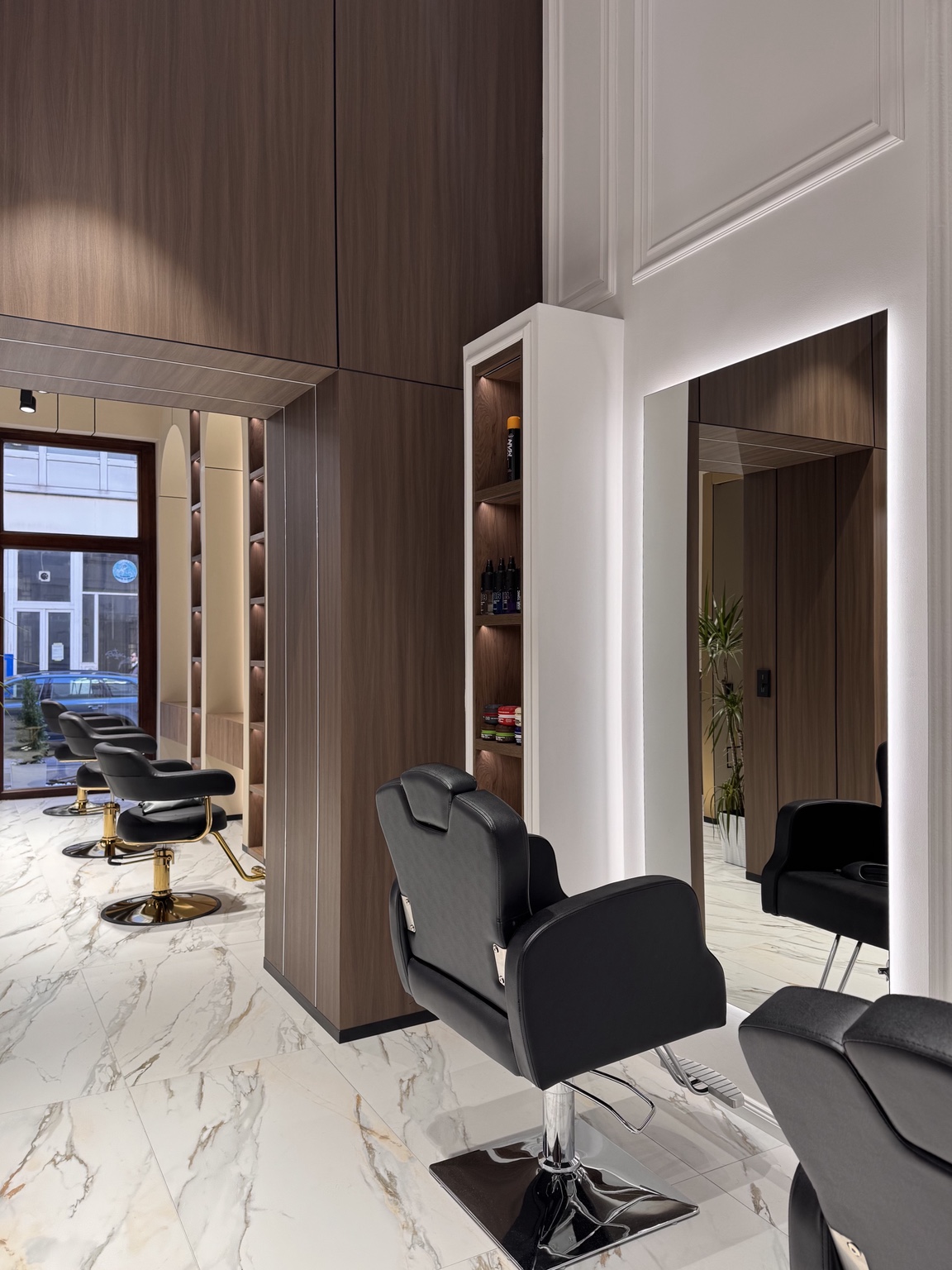 Barberstuhl vor einem beleuchteten Spiegel im Prestige Hair Salon